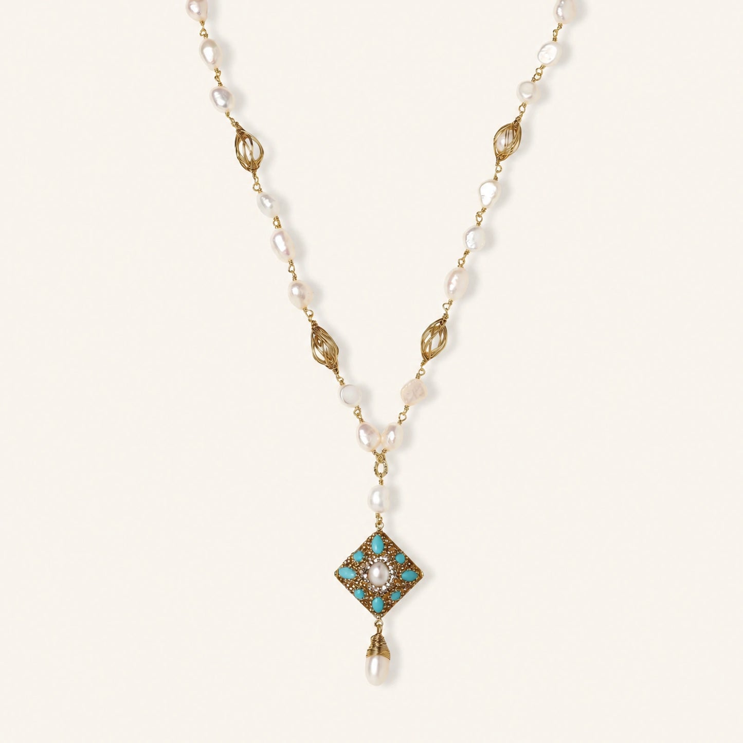 Y-shaped necklace with freshwater pearls, gold filigree stations, and ornate diamond-shaped centerpiece with pearl drop
