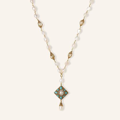 Y-shaped necklace with freshwater pearls, gold filigree stations, and ornate diamond-shaped centerpiece with pearl drop