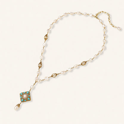 Y-shaped necklace with freshwater pearls, gold filigree stations, and ornate diamond-shaped centerpiece with pearl drop
